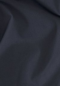Tissu bleu marine foncé avec une texture lisse et mate, présentant de légères plis et rides, indiquant un matériau léger.
