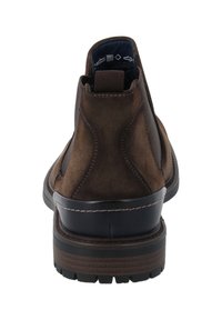 Bottes chelsea en suède marron avec un bout arrondi, des panneaux élastiques latéraux et une semelle en caoutchouc noire contrastante. Présente des détails de couture décoratifs.