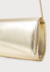 Zlatá metalická psaníčka s klopou a přišitou zlatou řetízkou na bílém pozadí.