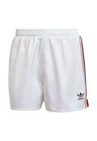 Bílé sportovní šortky vyrobené z hladké tkaniny. Mají boční pruhy v červené a černé barvě, elastický pas a černé logo na lemu.