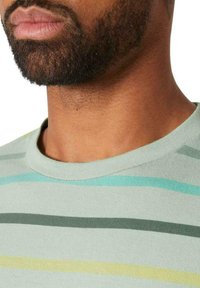 Camiseta de algodón verde claro con rayas horizontales en azul, verde oscuro y amarillo. Presenta un clásico escote redondo y una textura suave.