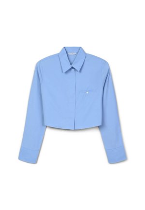 Blouse bleue courte en tissu léger, avec des manches longues, un col pointu et une poche poitrine avec un détail de bouton.