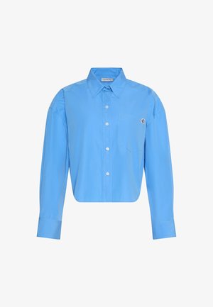 Ανοιχτό μπλε πουκάμισο με μακριά μανίκια, κουμπιά, μυτερό γιακά, τσέπη μπροστά και διακριτικό λογότυπο στο πάνω δεξί μέρος της τσέπης.