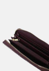 Portafoglio borgogna con zip realizzato in materiale testurizzato, dotato di più scomparti, hardware dorato e un layout interno organizzato.