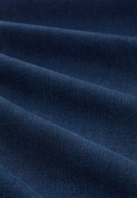 Tela azul marino con una textura suave, que presenta pliegues suaves y un brillo sutil. El material parece ligero y flexible.