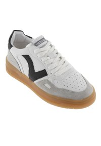 Sneaker bianca con accenti neri e grigi, dotata di punta perforata, forma arrotondata, lacci piatti e suola in gomma.