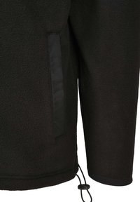 Giacca in fleece nera con superficie texture, dotata di una tasca laterale e di un cordoncino regolabile all'orlo per una vestibilità sicura.