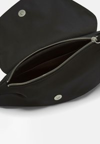 Czarna torba z tkaniny o gładkiej fakturze, z metalowym suwakiem, zapięciem na zatrzask i wewnętrzną kieszenią. Otwarta od góry, ukazująca podszewkę.