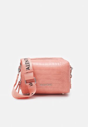 Sac bandoulière rectangulaire rose Valentino avec texture crocodile embossée et large sangle à logo, posé sur une surface blanche.