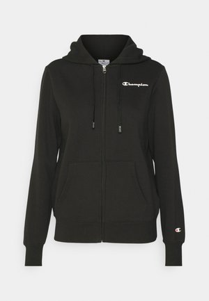Felpa nera con zip e cappuccio regolabile, due tasche frontali e logo "Champion" bianco sul petto. Realizzata in un morbido tessuto testurizzato.