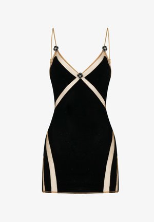 Mini robe noire avec bordure beige, fines bretelles, et boutons décoratifs en forme de fleur noirs et argentés au niveau de la poitrine et des épaules.