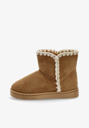 Botín de ante marrón con un interior suave y mullido, detalles en crema ondulados en la parte superior y una suela de goma plana.