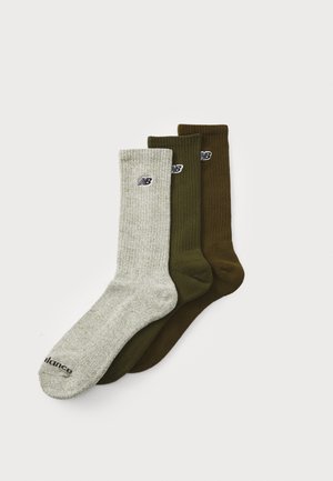 Tre vikta ankelsockor i ljusgrått, olivgrönt och brunt, var och en med en liten "NB"-logotyp nära den övre resåren.