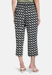 Pantalons cropped rayés avec un motif ondulé bleu marine et blanc cassé, dotés d'une taille élastique et d'une coupe ample.