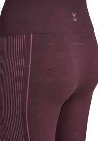 Bordowe legginsy o prążkowanej teksturze z bocznymi paskami. Posiadają wysoki stan i małą kieszonkę z tyłu. Wykonane z elastycznego materiału.