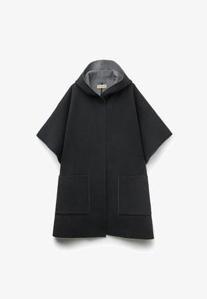 Sort uldponcho med hætte i grå kant, to forreste påsyede lommer og en løs, kasseformet silhuet. Har minimalt syning og ingen lukninger.