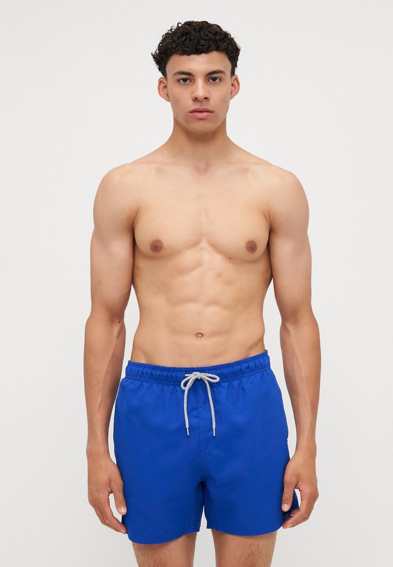Shorts de bain bleus en tissu léger, avec une taille élastique et un cordon de serrage. Le design est simple et a une texture lisse.