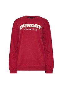 Sudadera roja de manga larga con la inscripción "SUNDAY dreaming" en letras blancas texturizadas en la parte frontal. Tejido suave y casual.