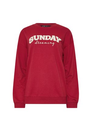 Punainen pitkähihaisia huppari, jossa edessä valkoiset tekstuurilla kirjaillut sanat "SUNDAY dreaming". Pehmeää, rentoa kangasta.