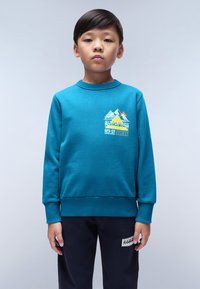 Sweatshirt turchese con polsini e orlo a coste, caratterizzato da una grafica di montagne e testo bianco, giallo e arancione sulla parte anteriore.