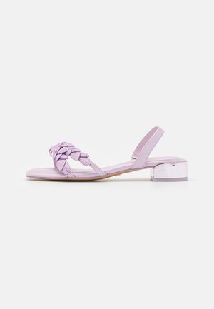 Lilla sandal med lav hæl og firkantet tå, flettet frontrem pyntet med små krystaller og elastisk slingback-rem.