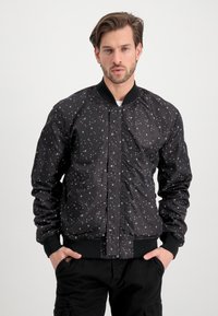 Black bomber jacket with a starry print in white. Features ribbed cuffs and collar, front zip closure, and two side pockets.