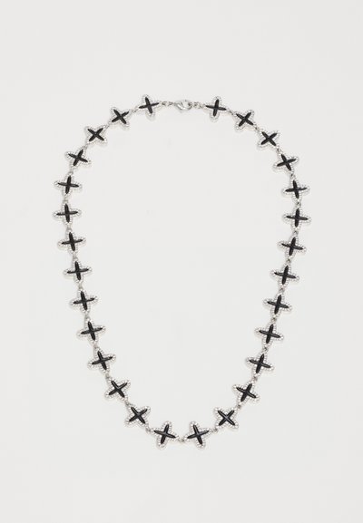 Collar de cadena de plata con eslabones en forma de cruz negra espaciados de manera uniforme sobre un fondo blanco, que cuenta con un cierre de langosta.