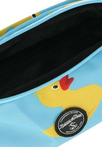 Blauwe stoffen zak met een ontwerp van een gele rubberen eend, zwarte binnenkant en een ronde zwarte logo patch met witte tekst. Ritssluiting.