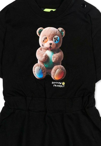 Vêtement noir avec un motif coloré d'ours en peluche comprenant des yeux-boutons dépareillés et le texte "Barrow Friendly" en dessous.