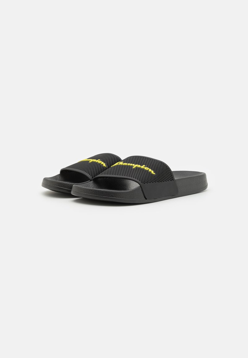 Schwarze Rutschsandalen mit einem strukturierten, atmungsaktiven Mesh-Obermaterial und einer soliden schwarzen Sohle. Mit gelbem besticktem Branding am Riemen.