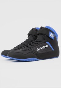 Baskets de sport noires avec des accents bleus, design montante, sangle de cheville ajustable, semelle extérieure texturée et logo sur le côté.