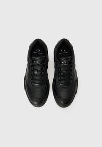Sneakers din piele neagră cu vârfuri rotunde, laterale texturate, design tradițional cu șireturi și detaliu perforat pe zona de vârf.