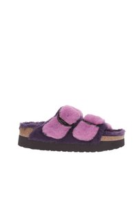 Zapatilla de felpa sintética con base morada y parte superior rosa. Presenta dos correas ajustables y una suela de corcho. Textura suave y diseño casual.