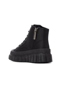 Zapatillas altas negras de cuero texturizado, con una suela gruesa acanalada, ojales de metal y cierre de cremallera en el lateral.