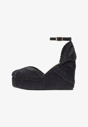 Scarpa platform con zeppa nera in tessuto strutturato, punta chiusa e arrotondata e cinturino alla caviglia con fibbia dorata.