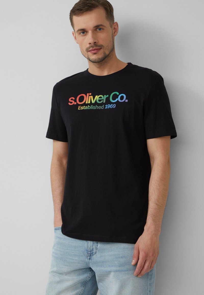 Schwarzes Baumwoll-T-Shirt mit einem mehrfarbigen Logo, das "s.Oliver Co. Established 1969" über der Brust liest; kurze Ärmel und lockere Passform.