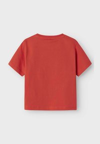 Camiseta roja de manga corta hecha de algodón, con un cuello redondo sencillo y un dobladillo recto. La tela presenta un diseño suave y casual.