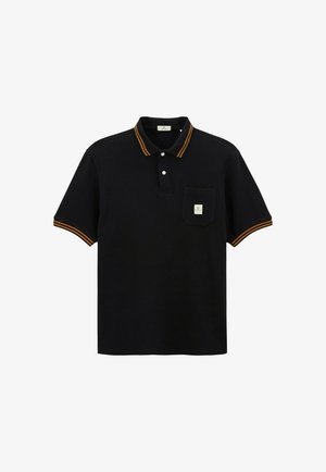 Polo-shirt noir à manches courtes avec des rayures orange sur le col et les poignets, deux boutons blancs, et une petite poche avec une étiquette sur la poitrine.