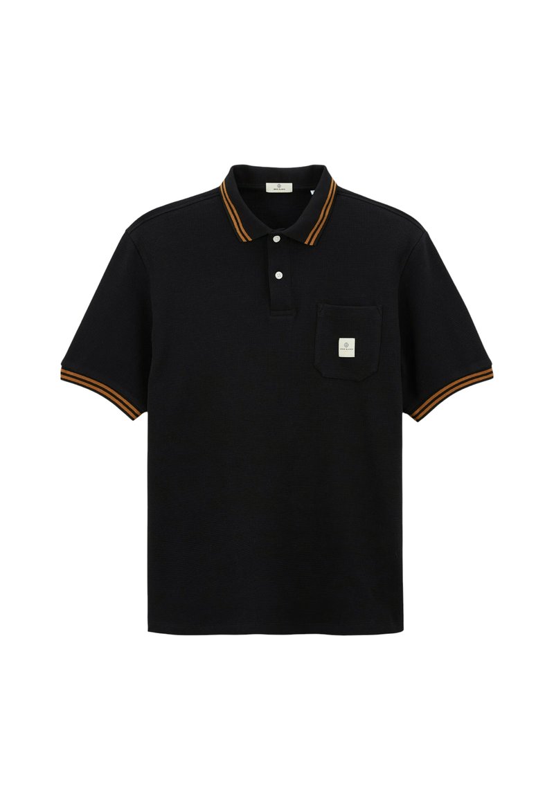 Polo-shirt noir à manches courtes avec des rayures orange sur le col et les poignets, deux boutons blancs, et une petite poche avec une étiquette sur la poitrine.