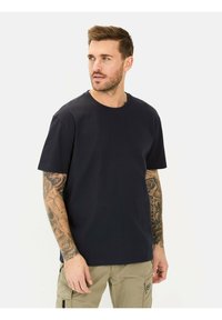 Marineblauwe katoenen T-shirt met een ronde hals, korte mouwen en een ontspannen pasvorm. De stof lijkt glad en lichtgewicht.