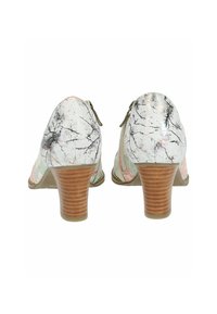 Scarpe con tacco con una tomaia texture, multicolore, caratterizzata da motivi astratti. Il tacco è in legno e a strisce, offrendo una base stabile.