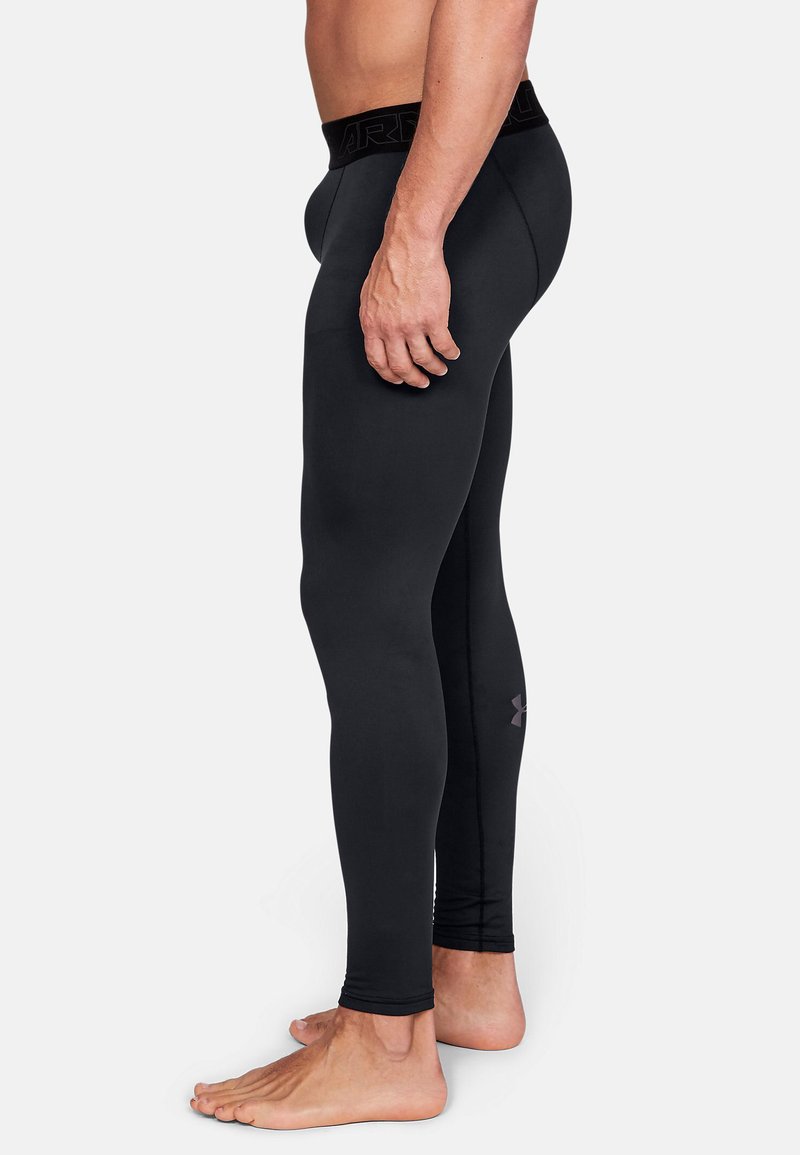 Schwarze sportliche Leggings aus glattem, dehnbarem Material mit einem strukturierten schwarzen Bund und einem dezenten Logo-Detail an der Unterschenkel.