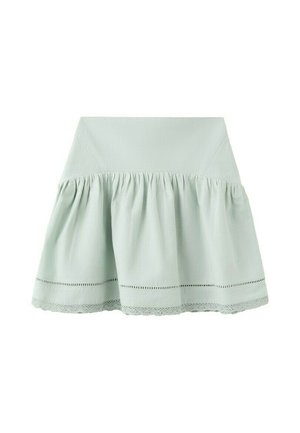 Jupe taille haute vert clair avec tissu froncé et bordure en dentelle le long de l'ourlet, présentée sur un fond blanc.