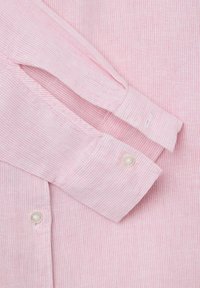 Light pink striped shirt featuring a soft texture, button cuff detailing, and small white buttons for fastening.