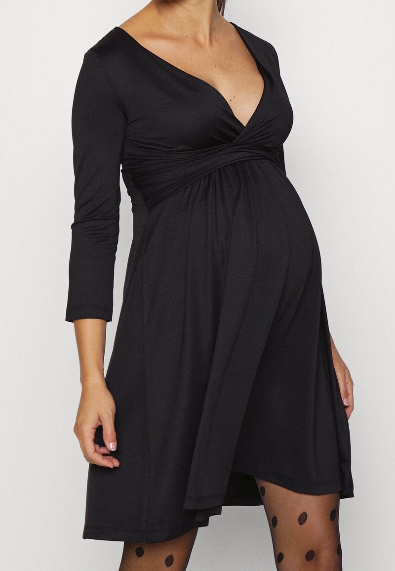 Svart gravidklänning med V-ringning, trekvartsärmar och samlad midja, med ett mjukt, elastiskt tyg och en flödande kjol.