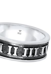 Silberring mit einem strukturierten schwarzen Band und polierten Silberakzenten. Innen im Band mit "925" markiert, was auf die Qualität von Sterlingsilber hinweist.