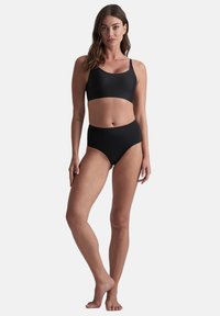 Set di bikini nero con top bralette a spalline larghe e slip a vita alta. Tessuto liscio, design semplice, senza motivi o dettagli.