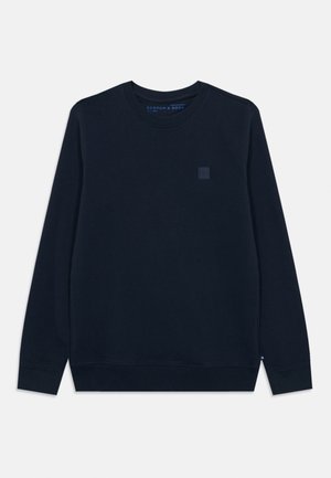 Sweatshirt bleu marine en tissu doux en mélange de coton. Il présente un col rond, des manches longues et un petit logo carré sur la poitrine.