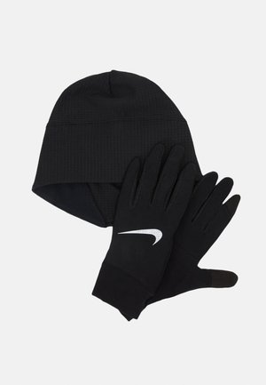Bonnet noir avec texture côtelée et gants noirs arborant un logo Swoosh blanc de Nike. Les deux articles sont en tissu extensible.