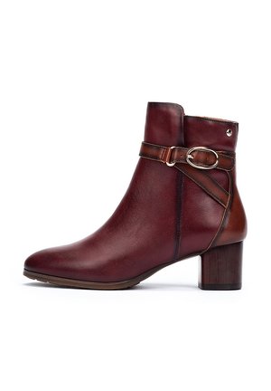 Bottine en cuir bordeaux avec un orteil arrondi, accent brun, boucle décorative et un talon moyen en bloc. Texture lisse et lignes épurées.